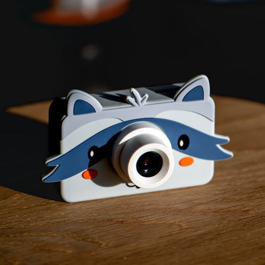 Appareil photo numérique pour enfant Raton laveur posé sur une table en bois