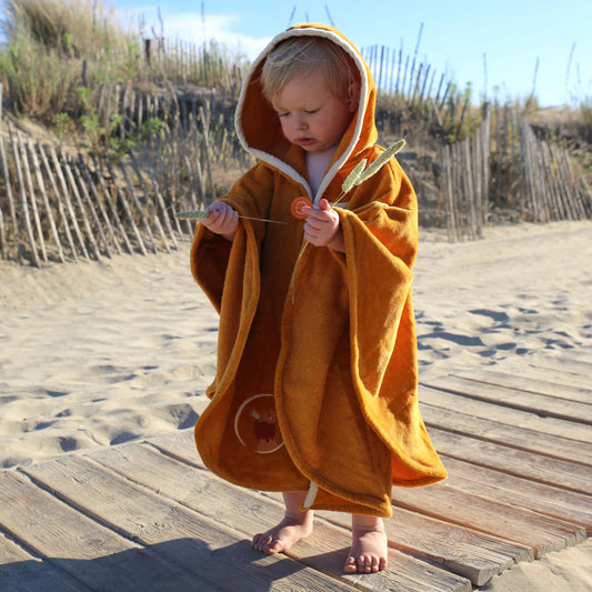 Cape de bain bébé jaune personnalisée prénom brodé portée à la plage