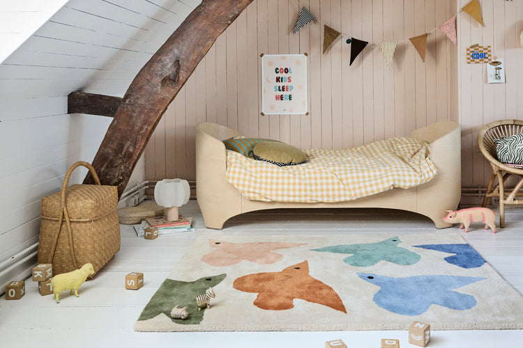 Chambre enfant beige, tapis oiseaux nature, beige bleu terracotta.