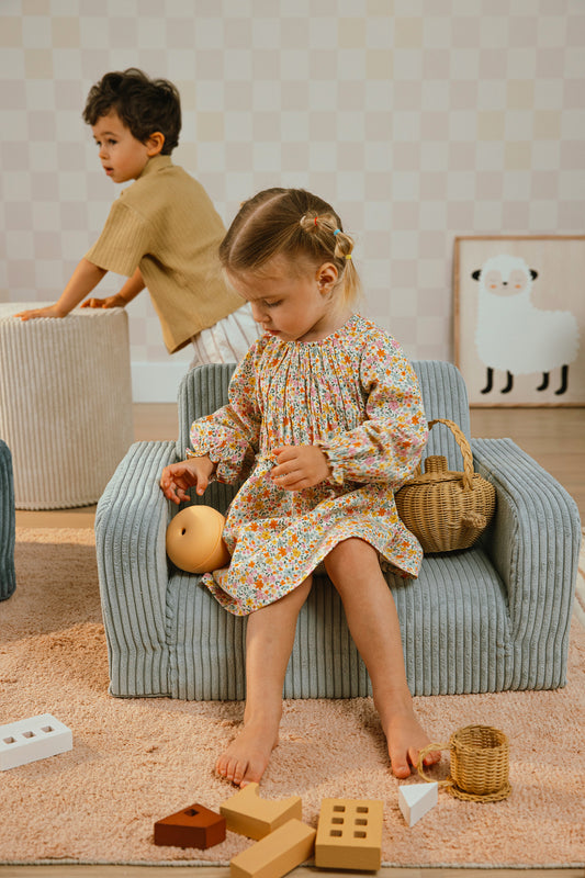 Petite fille installée sur un fauteuil enfant vert en velours Shappy