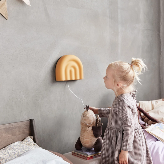 Décoration chambre enfant OYOY Mini. Lampe murale avec prise et interrupteur, pour chambre d'enfant. Jaune en forme d'arc-en-ciel. Légère en silicone.