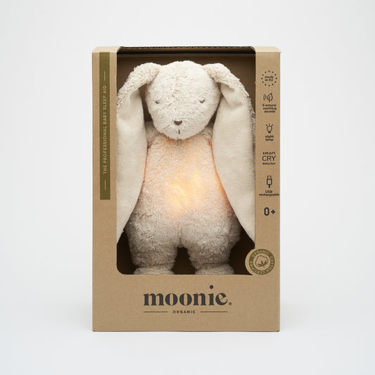 Peluche pour endormir bébé Moonie, lapin beige sable avec veilleuse et sons apaisants.