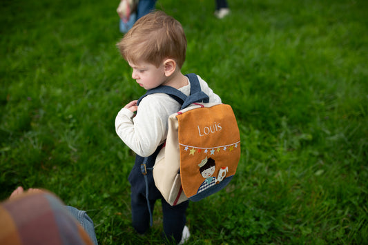 Enfant portant sac à dos maternelle personnalisé Petit Chien jaune pendant la récré