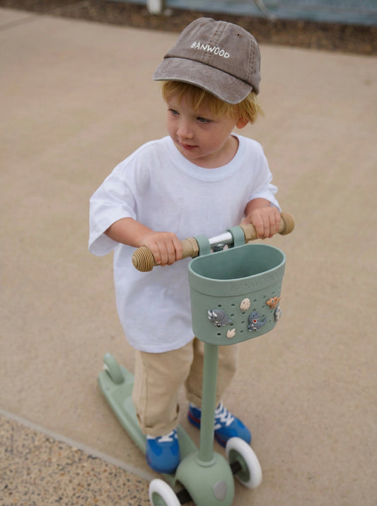 Trottinette verte Banwood pour enfant dès 3 ans avec panier décoré et pin's dinosaures