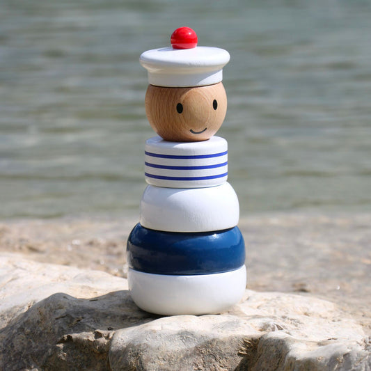 Jouet à empiler marin VILAC en bois posé sur un rocher – cadeau bébé 1 an, extérieur.
