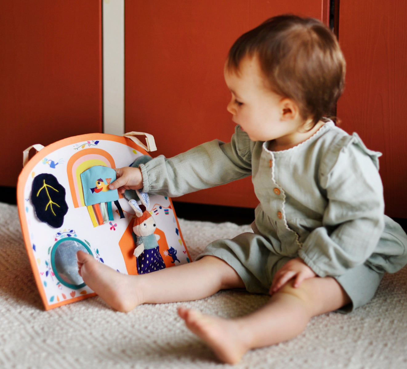 Idée cadeau de naissance originale, dès la naissance le panneau d'activités en tissu est parfait pour faire découvrir les sons, les matières, les couleurs à bébé.