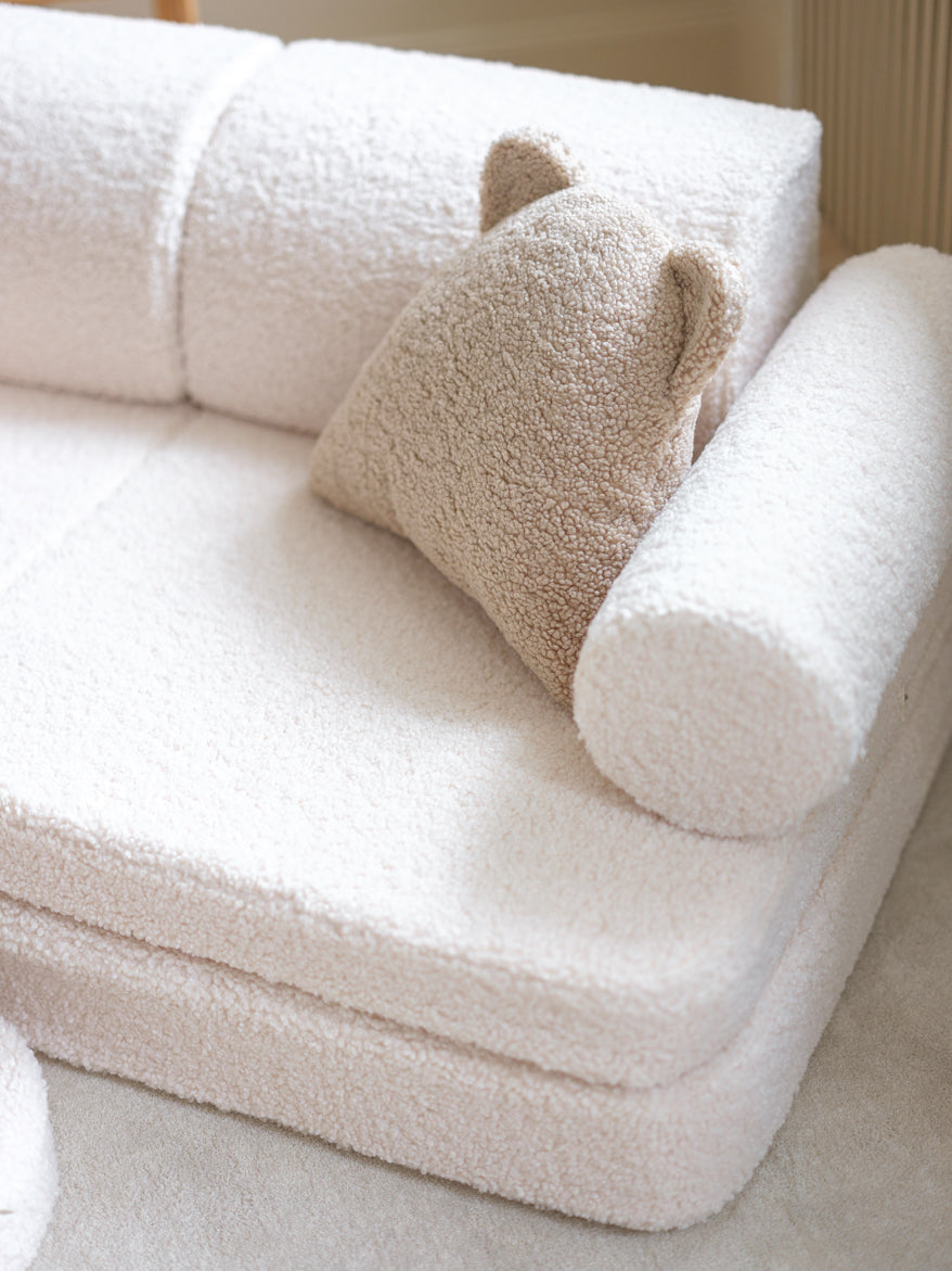 Vue latérale du canapé modulable blanc bouclette pour enfants. Coussin ourson beige.