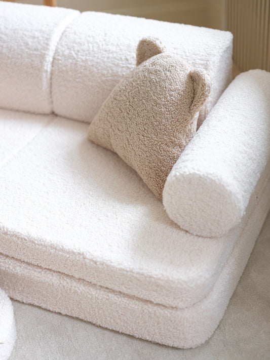 Vue latérale du canapé modulable blanc bouclette pour enfants. Coussin ourson beige.