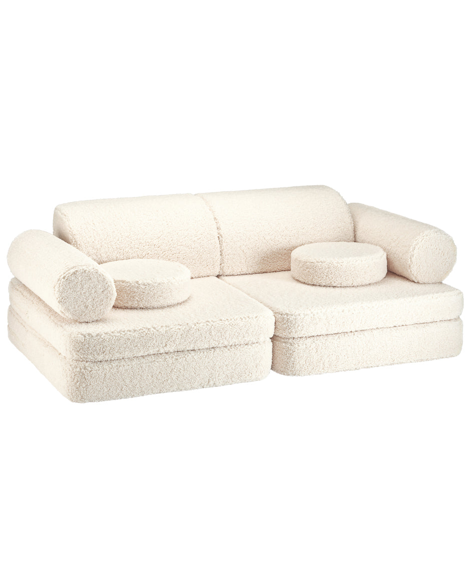 Canapé modulable blanc doux et confortable, pour coin lecture ou repos chambre enfant.