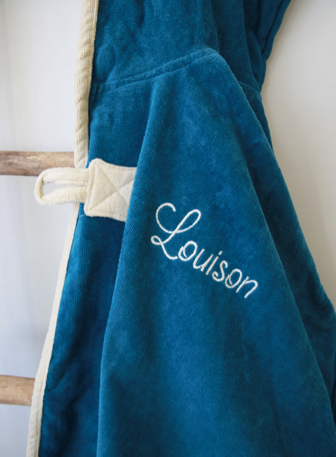 Détail prénom brodé sur cape de bain bébé bleue personnalisée