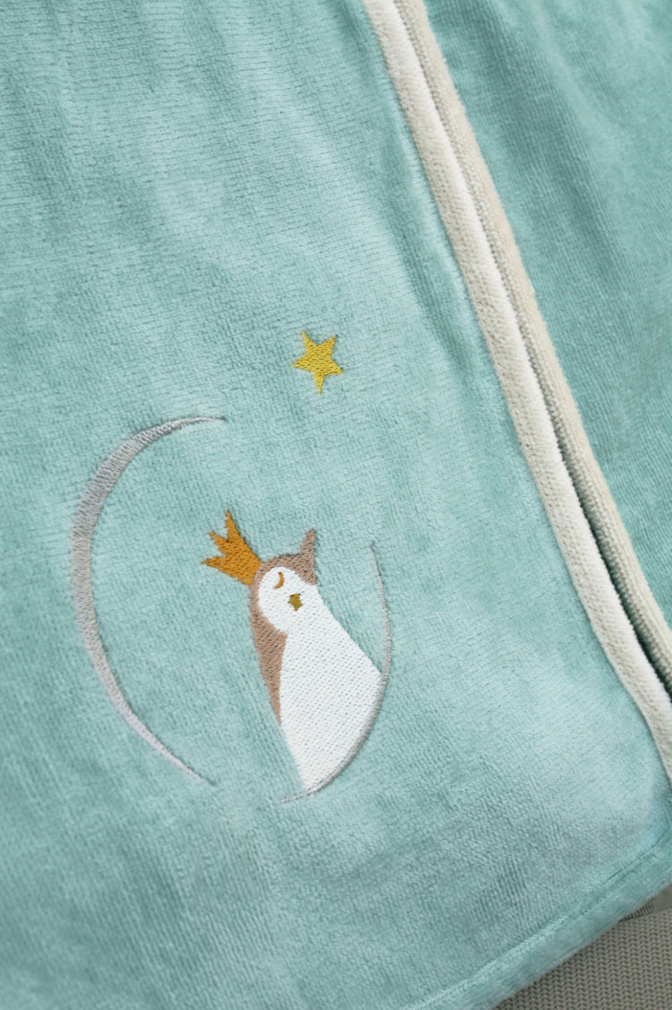 Détail broderie pingouin sur cape de bain bébé personnalisée vert clair