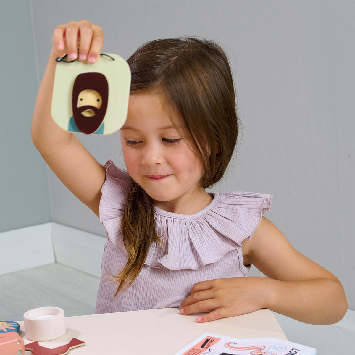 Fille jouant à coiffer sa poupée avec un set de coiffure en bois complet