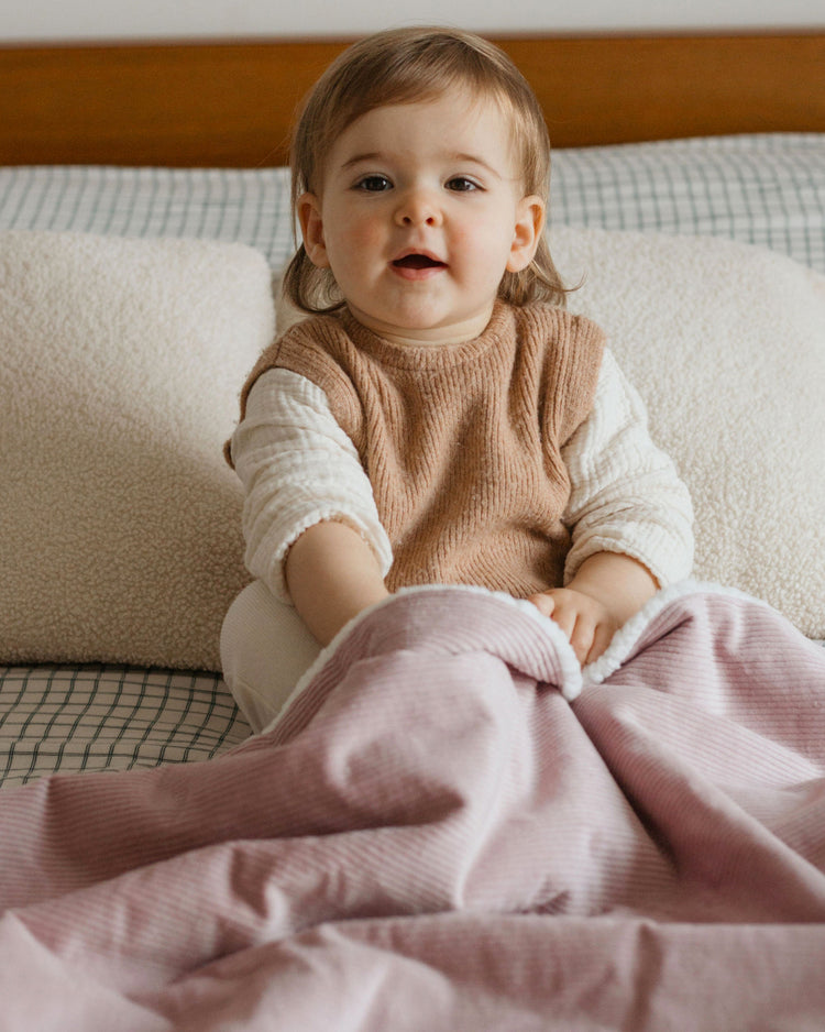 Couverture prénom bébé lila posée sur le lit, idée cadeau naissance.