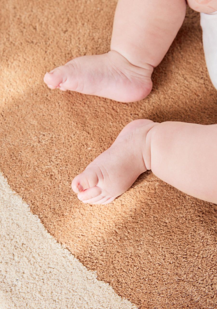 Détail du tapis mouton beige et moka en coton bio, idéal pour la décoration de chambre bébé