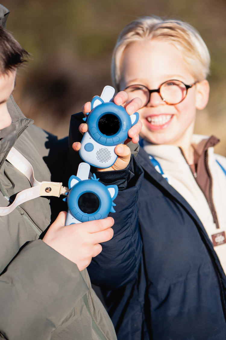 Deux enfants qui jouent ensemble avec leur paire de talkies-walkies Raton laveur pendant une balade