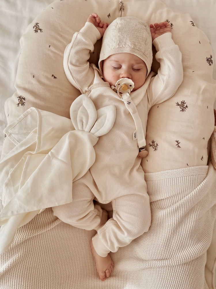 Doudou lapin en coton bio, une belle idée cadeau pour apaiser et rassurer bébé dès la naissance. Avec un attache tétine pratique. 