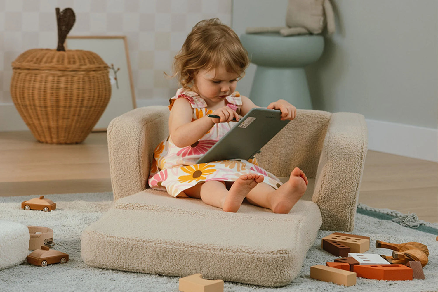 Fauteuil lecture enfant beige utilisé dans un coin lecture avec jouets.