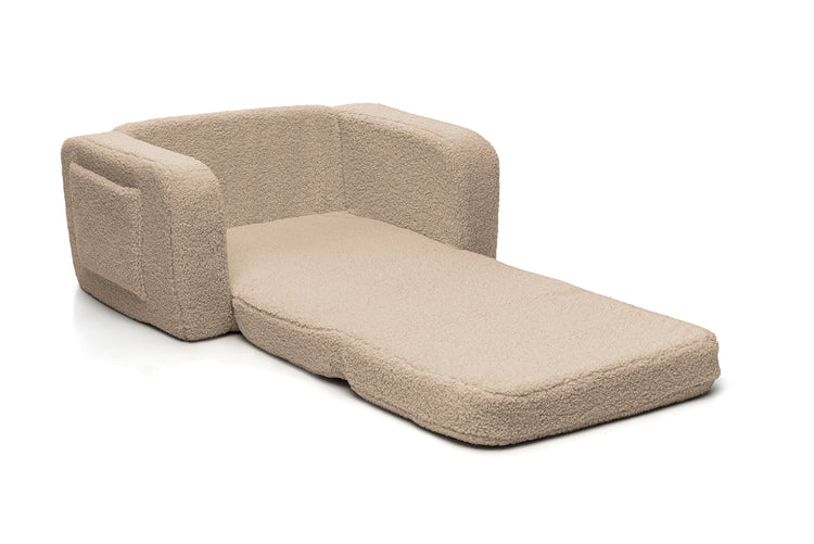 Fauteuil enfant beige déplié en tapis de repos modulable.