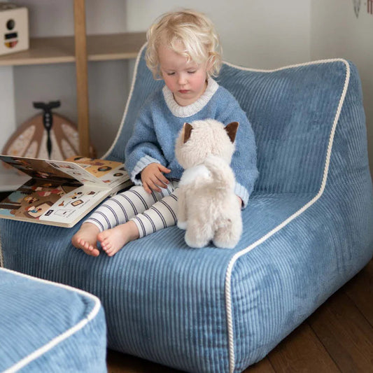 Jeune enfant jouant dans un fauteuil enfant bleu en velours. Kumo, Shappy.