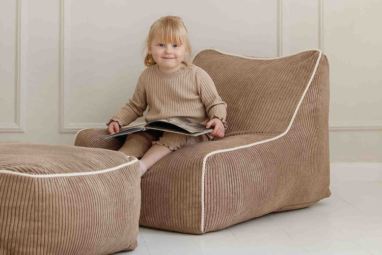 Fauteuil enfant Kumo Shappy en velours côtelé marron chocolat en velours avec repose-pieds dans une chambre d’enfant élégante