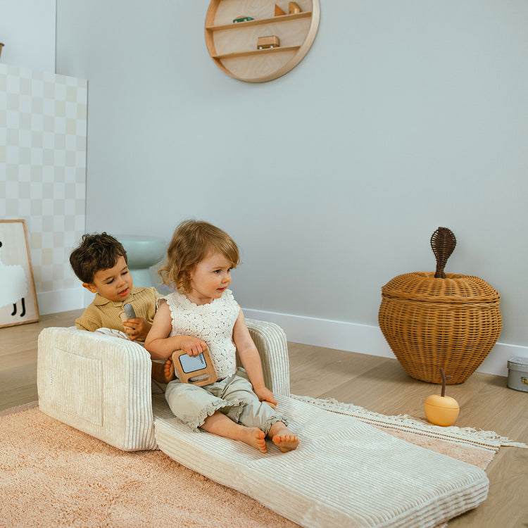 Enfants jouant avec fauteuil enfant velours vanille.