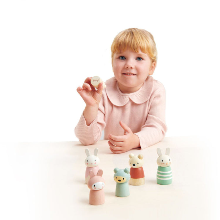 Enfant jouant avec des figurines lapins en bois pour inventer des histoires
