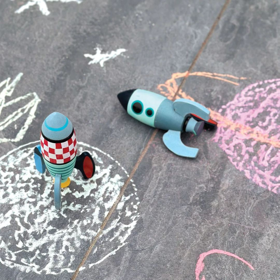 Deux fusées en bois sur un décor spatial dessiné à la craie