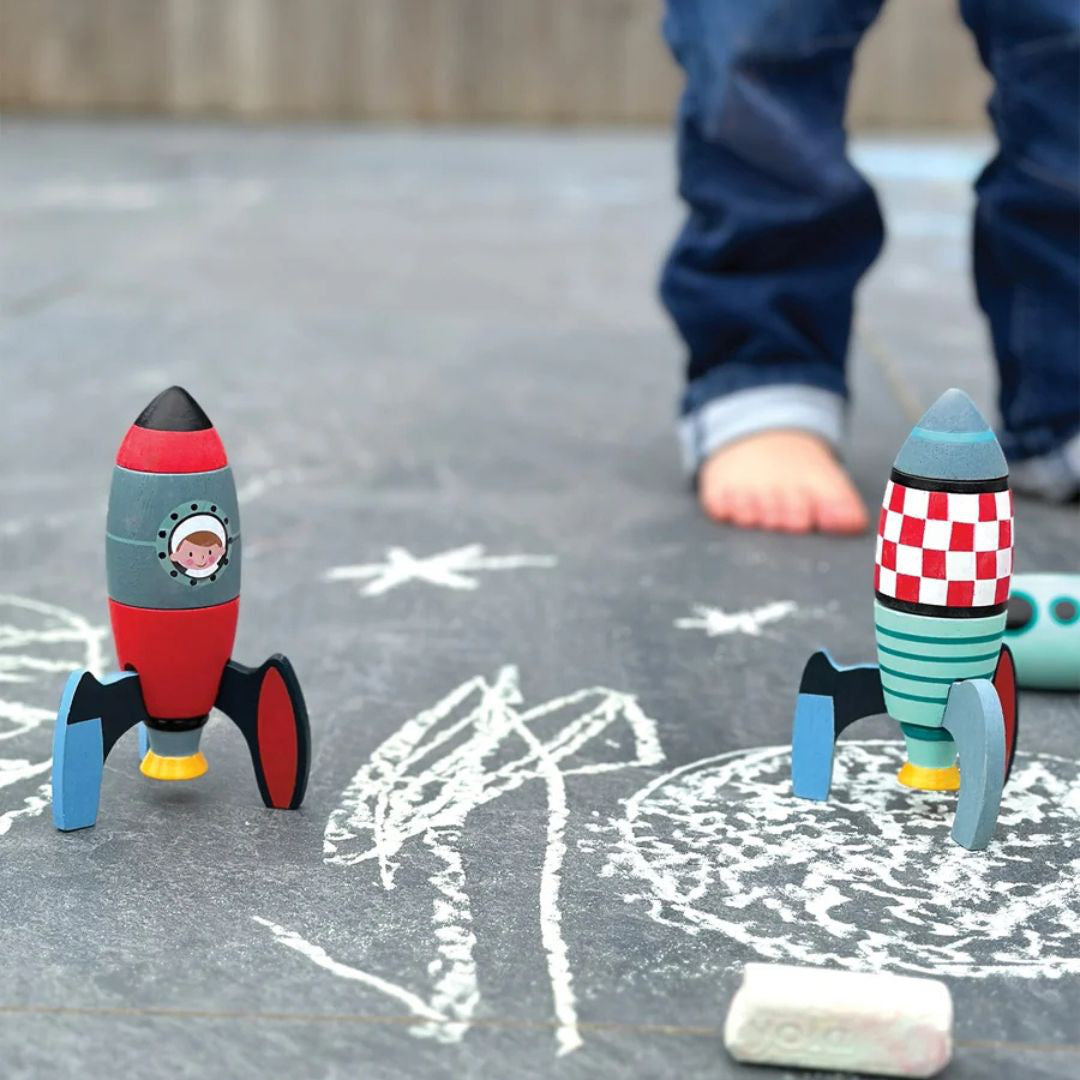 Fusées en bois posées sur une planète dessinée à la craie près d'un enfant