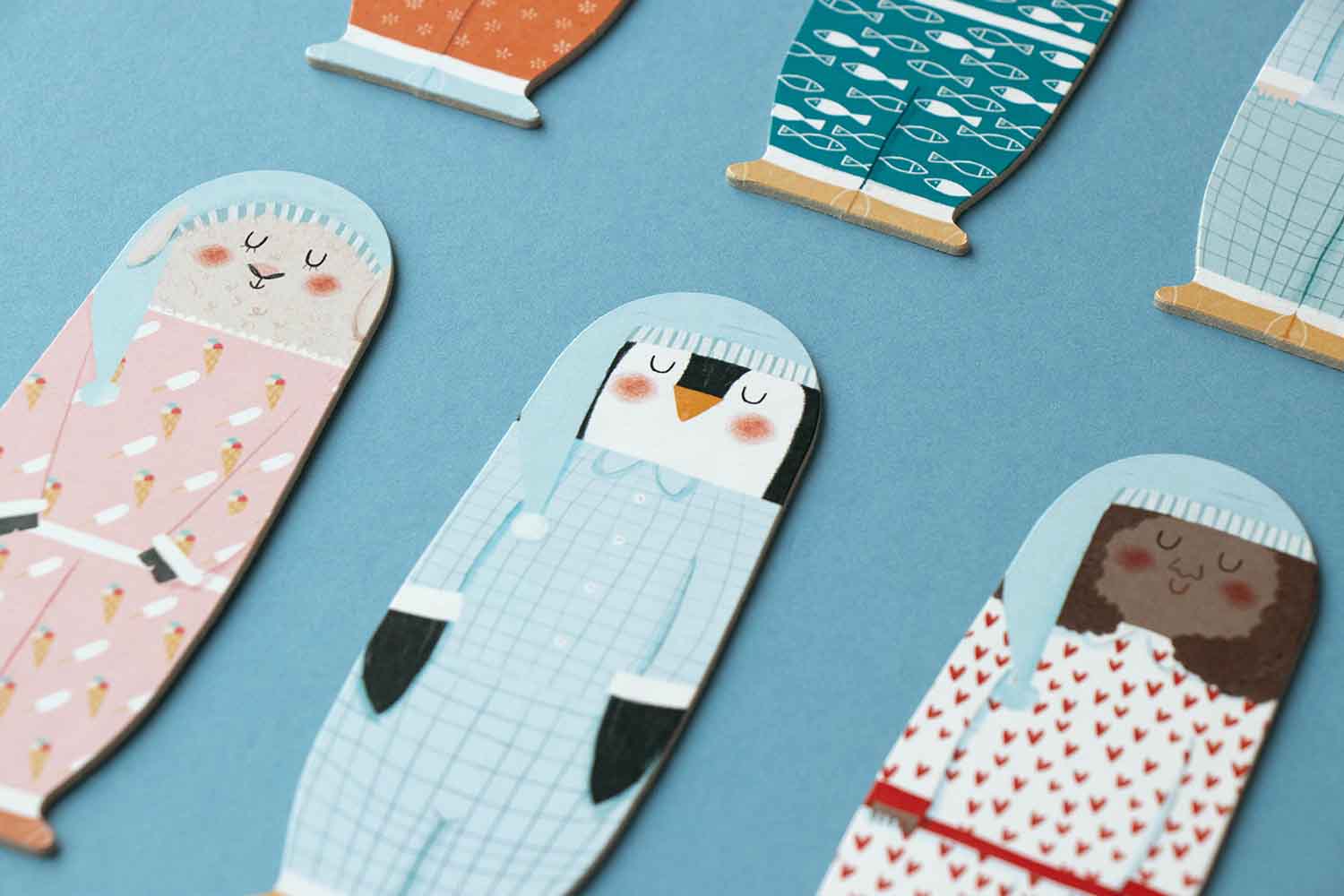 Zoom sur les personnages du jeu de société pour enfant Londji : 3 silhouettes endormie, en pyjama, un petit mouton, un pingouin et une fillette. 