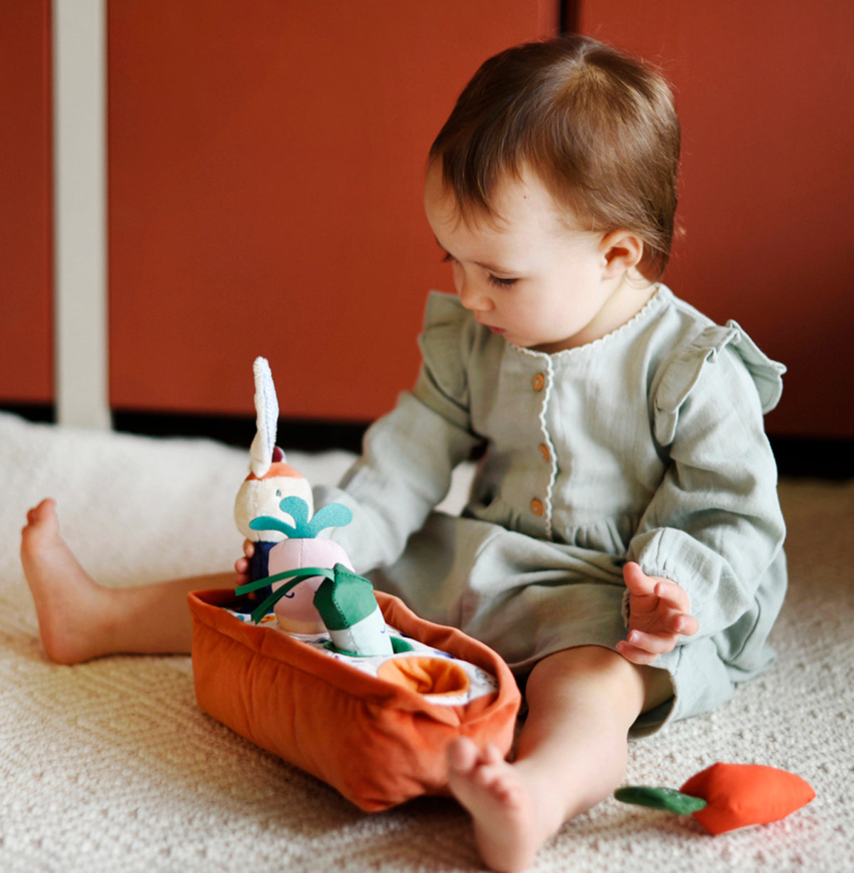 Jouet en tissu permettant à bébé d'encastrer les objets, dès l'âge de 6 mois. Encourage et accompagne le développement de la motricité fine et des capacités de coordination et de logique.