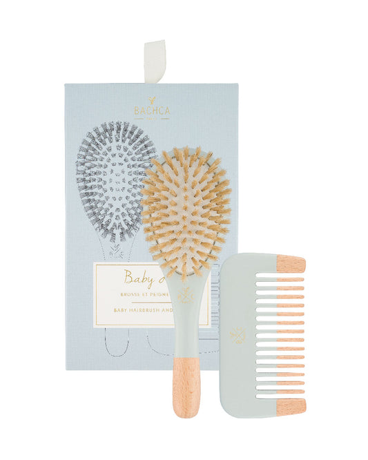 Photo sur fond blanc du coffret et de son contenu : coffret cartonné bleu, logo et écritures dorées Bachca Paris, brosse en  bois naturel. Brosse pour cheveux bouclés ou lisses de bébé. Peigne en bois et couleur bleu pâle satin. Matériaux nobles et durables. Bachca Paris.