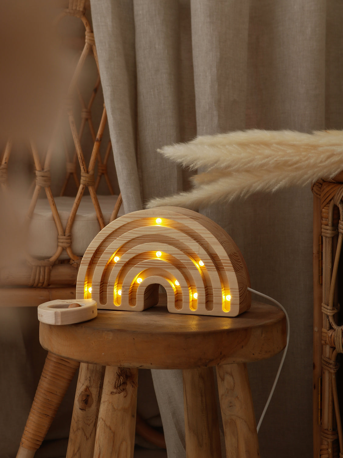 Lampe arc-en-ciel en bois posée en décoration de chambre bébé