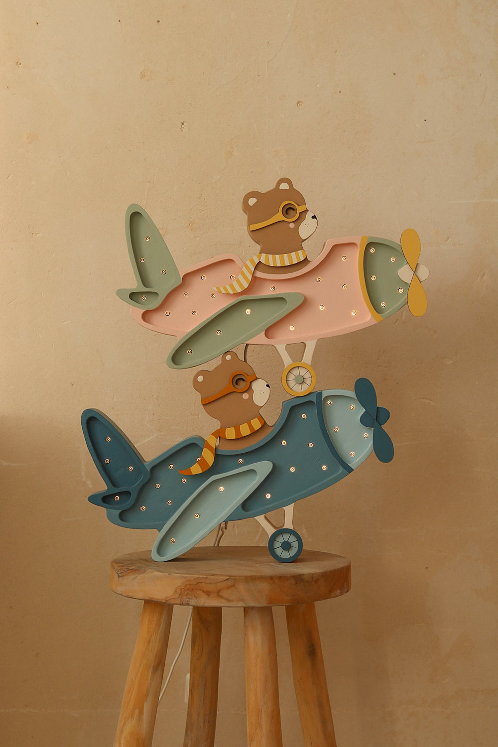 Luminaires avion bois pour une déco vintage d’enfant. Modèle ourson pilote, Little Lights bleu et candy rose pastel.
