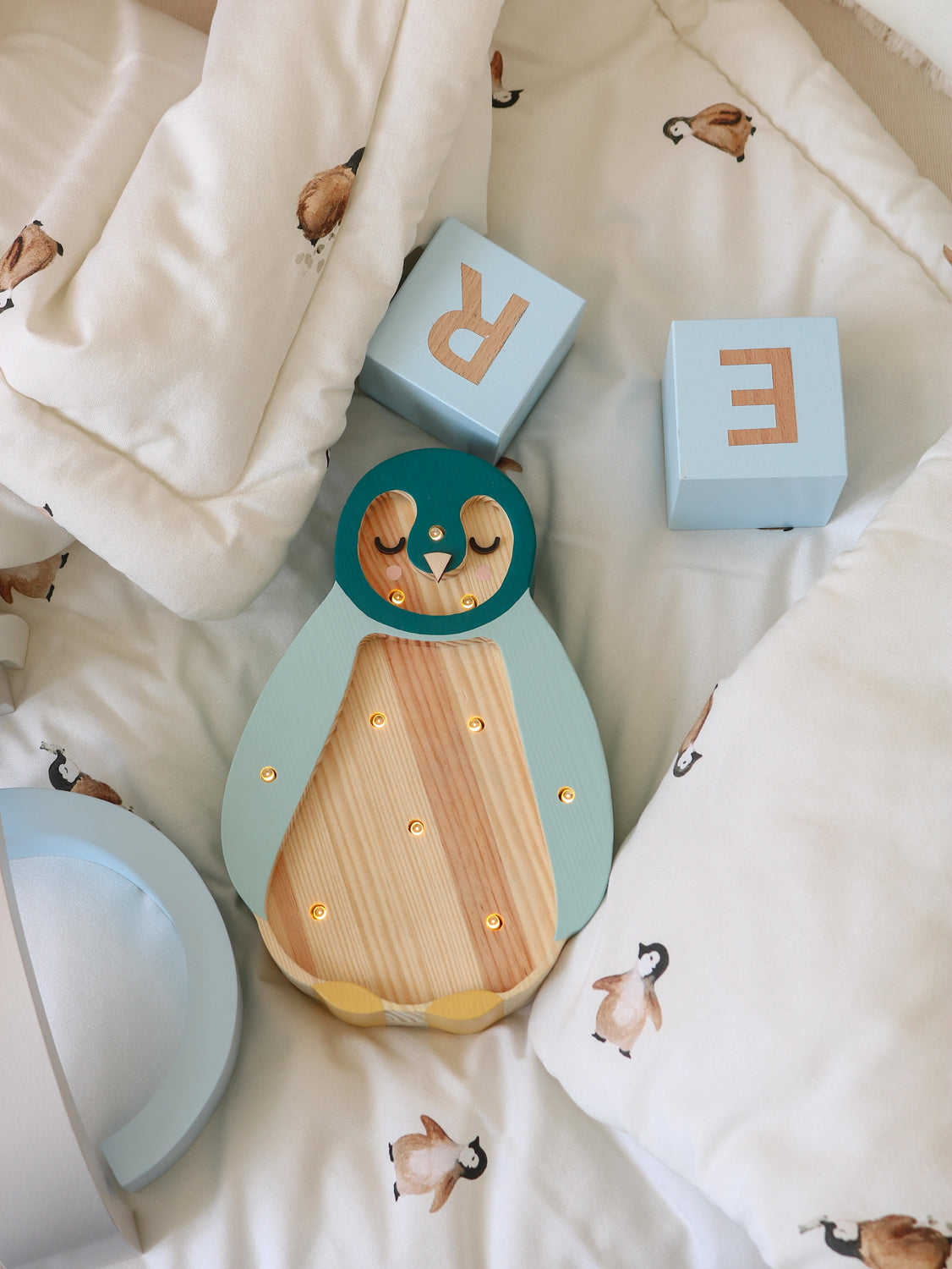 Lampe veilleuse en bois posée près d’un lit bébé