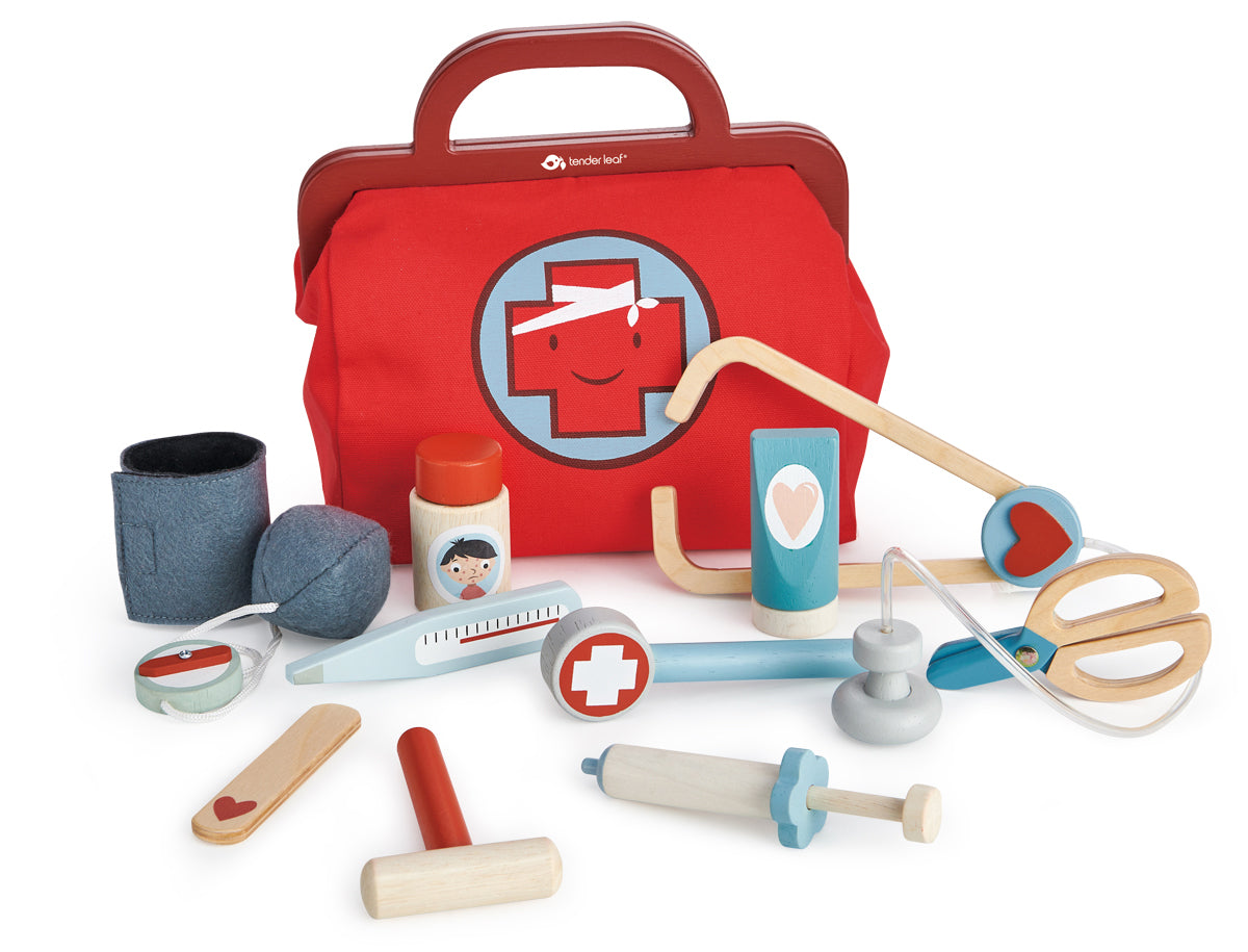 Panoplie de docteur Tender Leaf : mallette en tissu rouge contenant un stéthoscope, des ciseaux, un thermomètre, une seringue, un marteau de réflexe, un tensiomètre, un masque en tissu, des pansements, des autocollants indiquant les affections et les remèdes, une feuille de soin, un bâton plat, un tube de pommade et un médicament. 