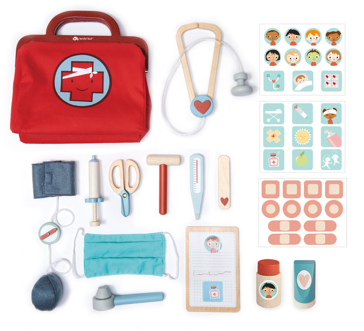 Contenu de la valise de docteur et ses jouets en bois pour enfant dès 3 ans : un stéthoscope, des ciseaux, un thermomètre, une seringue, un marteau de réflexe, un tensiomètre, un masque en tissu, des pansements, des autocollants indiquant les affections et les remèdes, une feuille de soin, un bâton plat, un tube de pommade et un médicament. 
