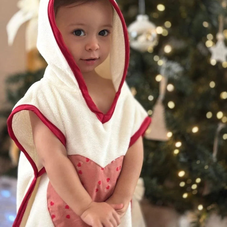 Poncho de bain bébé personnalisé porté par un enfant, idéal pour la plage et les vacances