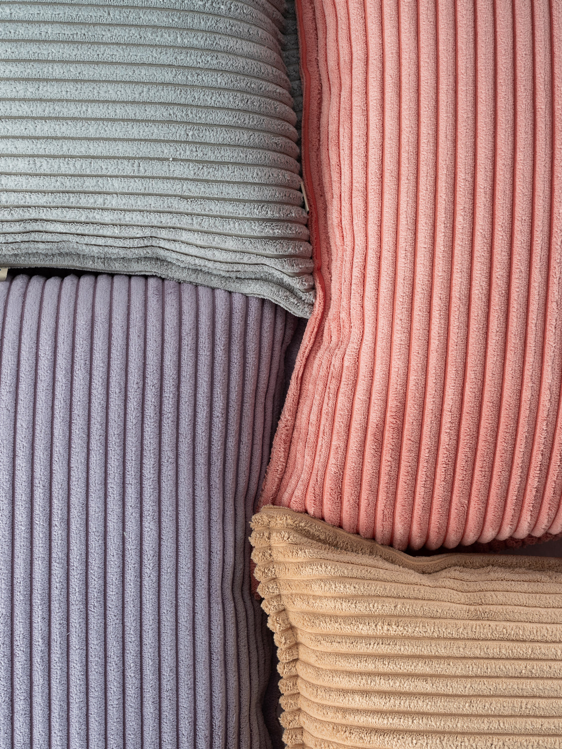 Zoom sur les tissus velours côtelés des poufs poires Wigiwama. Coloris Bleu Myrtille, rose, sucre brun et vert menthe. Production écoresponsable en Europe, velours côtelé produit à partir de bouteilles recyclées. 