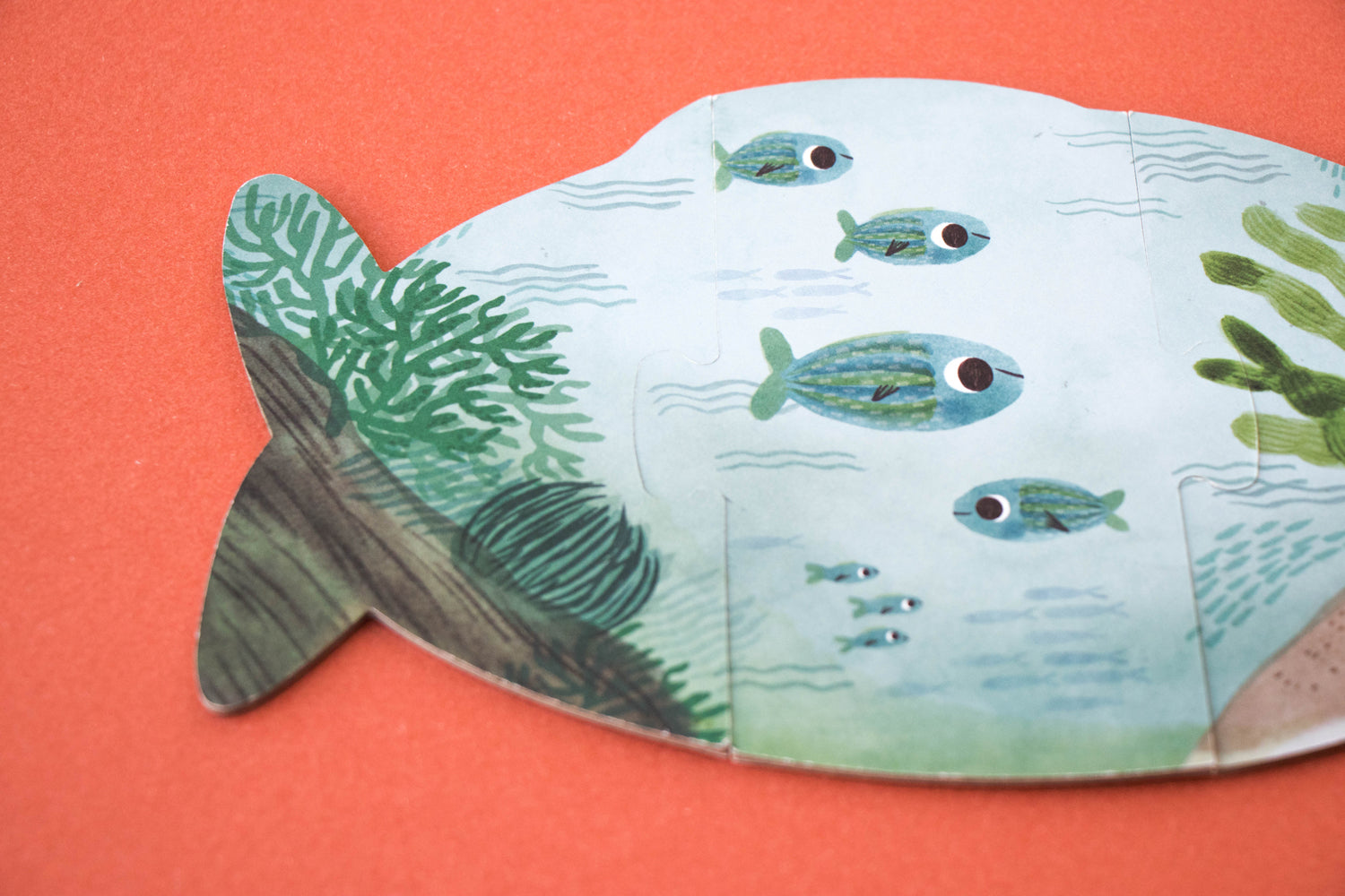 Zoom sur le verso du puzzle poisson. Des matériaux respectueux de l'environnement. Dessins poétiques et amusants.