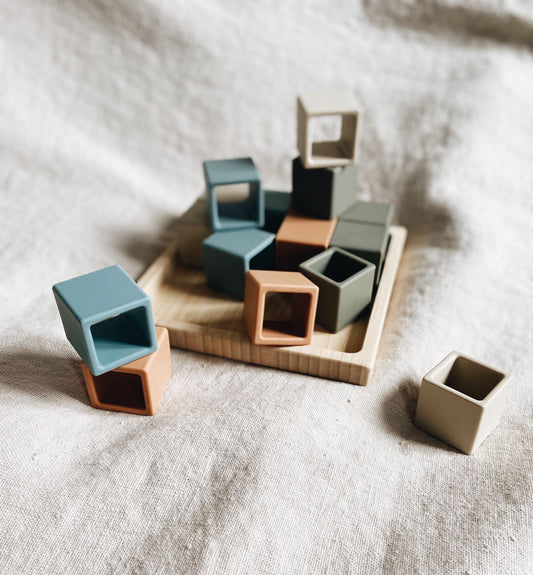 Inspiration de construction avec les cubes en silicone, intérieur creux, de Leo et Lea. Ici posé sur et en dehors de leur plateau en bois. 