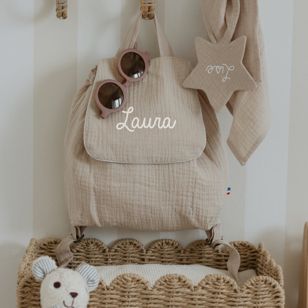 Sac à dos maternelle personnalisé beige en double gaze, prénom brodé, ambiance chambre enfant, fabrication française.
