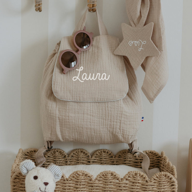 Sac à dos maternelle personnalisé beige en double gaze, prénom brodé, ambiance chambre enfant, fabrication française.