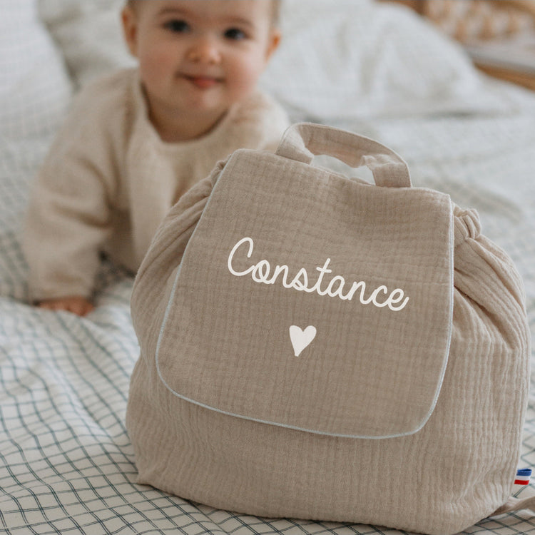 Sac à dos maternelle personnalisé en double gaze beige, vue de face avec motif cœur, doux et léger.