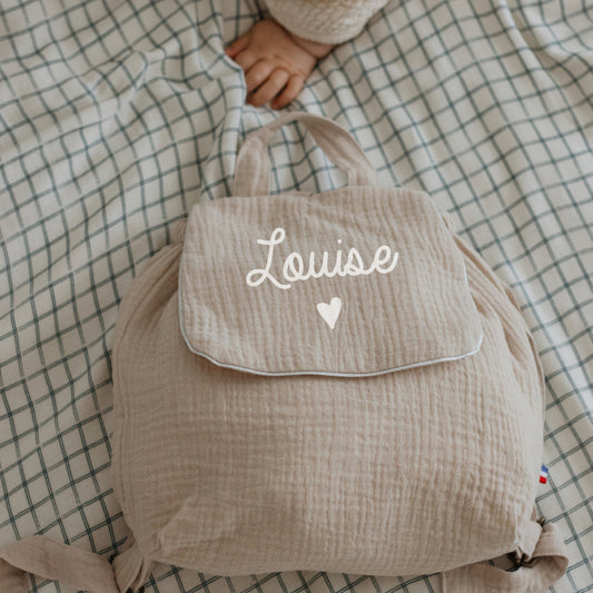 Sac à dos maternelle personnalisé en double gaze beige avec motif cœur sous le prénom, cadeau de naissance.