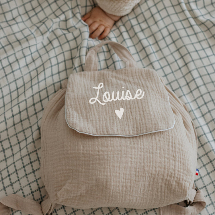 Sac à dos maternelle personnalisé en double gaze beige avec motif cœur sous le prénom, cadeau de naissance.
