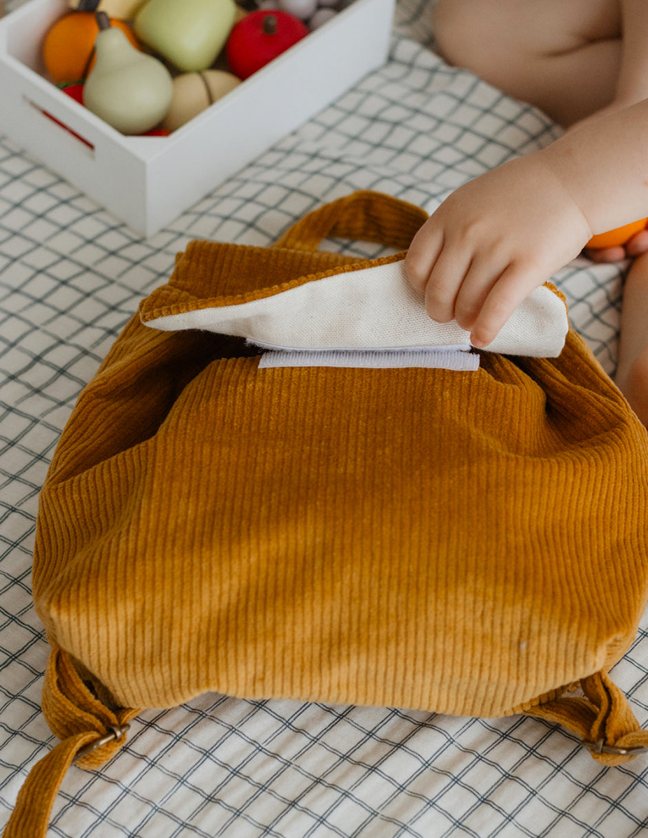 Détail ouverture scratch du sac à dos maternelle personnalisé en velours côtelé moutarde.
