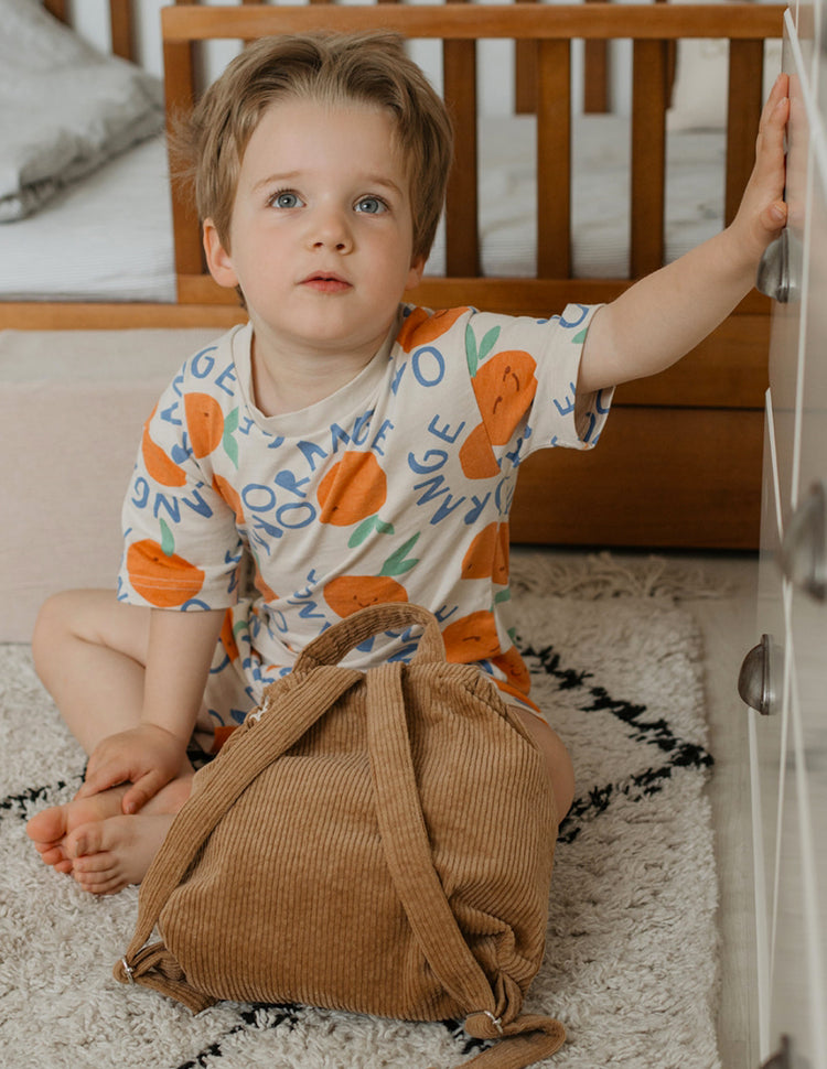 Sac à dos velours côtelé enfant, look automne marron clair, photo ambiance chambre, idéal doudou et goûter.