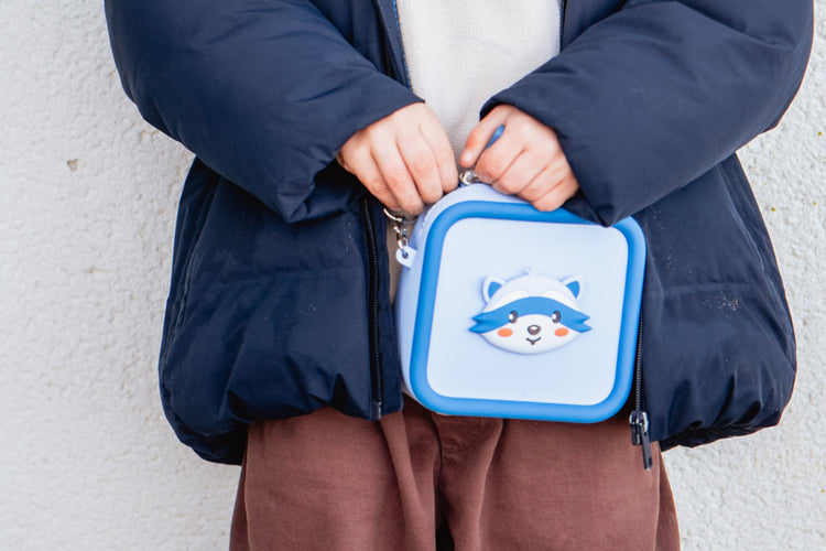 Enfant tenant les attaches de son sac de transport Raton laveur bleu The Zoo Family