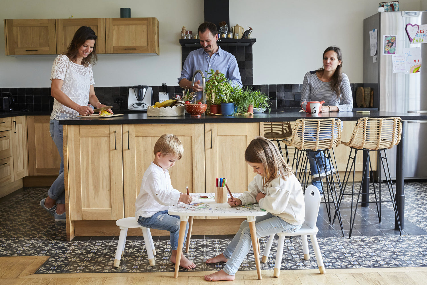 Deux enfants dessinent sur une table coloriage enfant avec chaise dans la cuisine