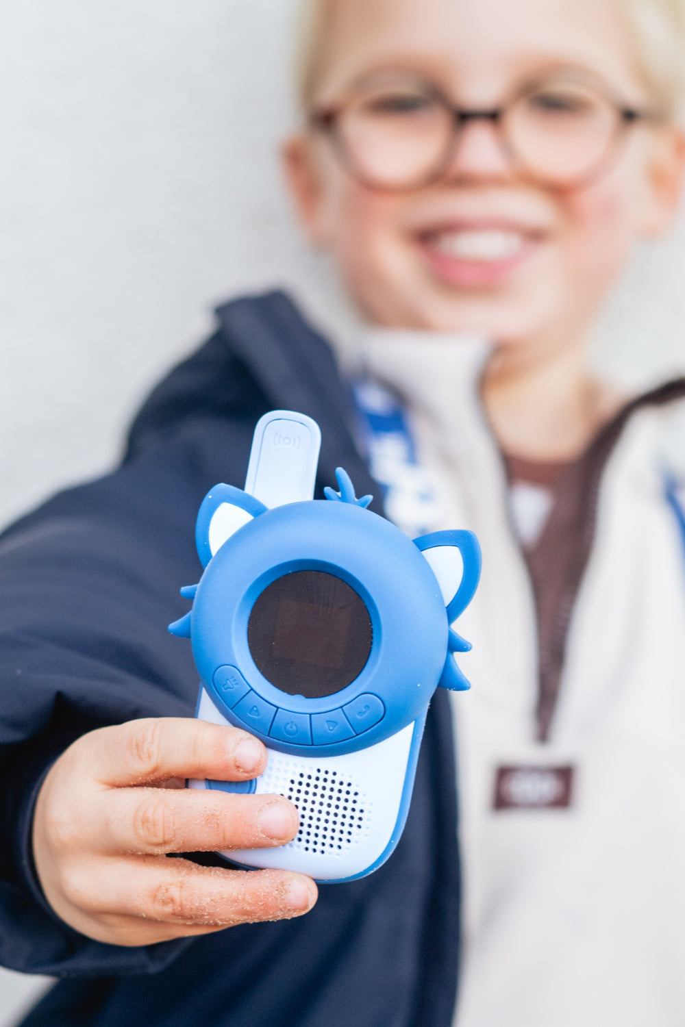 Enfant qui tend son talkie-walkie Raton laveur, au format compact pensé pour les petites mains